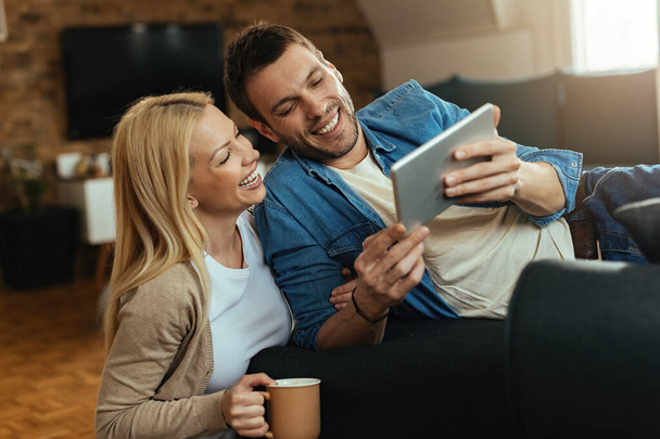 Genç mutlu çift evde dijital tablet kullanırken eğleniyor..  - Fotoğraf, Görsel