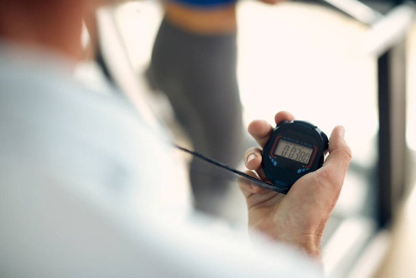 Close-up of personal trainer using stopwatch during exercise class in a gym.  - Valokuva, kuva