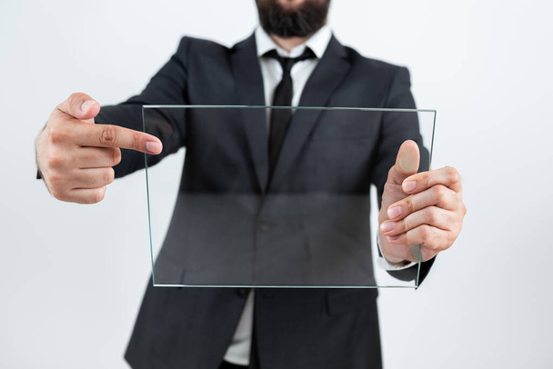 Бизнесмен держит прозрачное стекло и продвигает бренд компании. - Фото, изображение