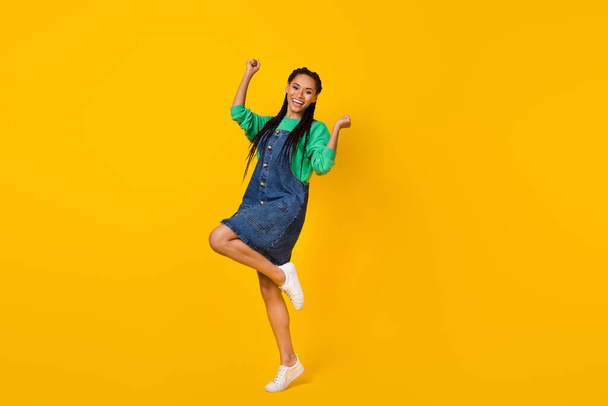 Full body photo of delighted positive girl raise fists celebrate triumph luck isolated on yellow color background. - Φωτογραφία, εικόνα