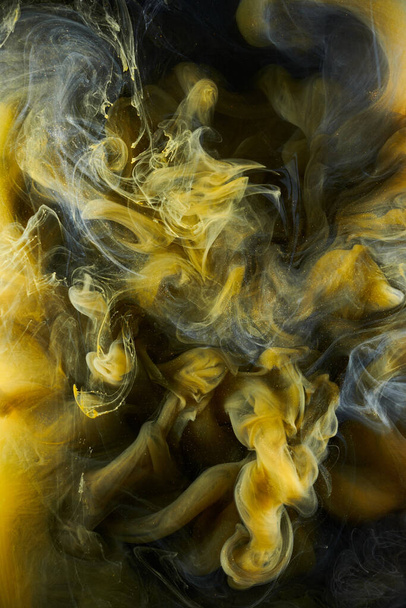 Liquid fluid art abstract background. Black, yellow dancing acrylic paints underwater, space smoke ocean - 写真・画像