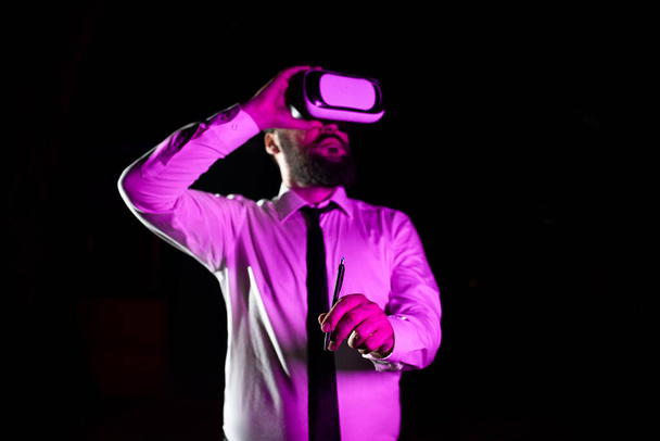 Hombre sosteniendo la pluma durante la formación profesional a través de la realidad virtual. - Foto, Imagen