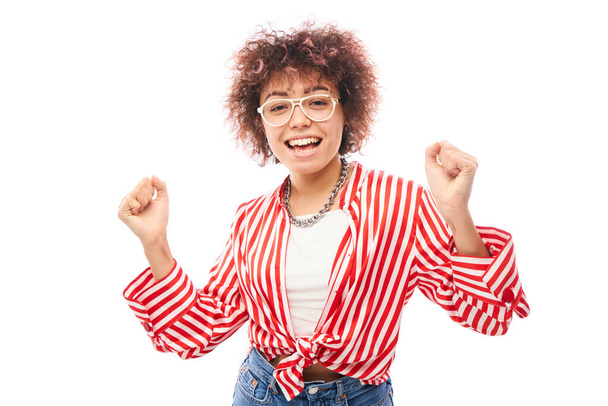 Positive lucky kazakh girl with afro hairstyle laughing rejoices celebrating victory, heard good news isolated on white background - Фото, зображення