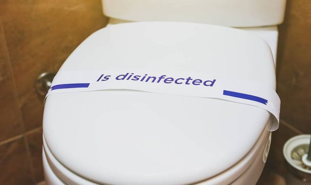 Vaschetta da bagno bianca con cartello disinfettato. Bagno in hotel. - Foto, immagini