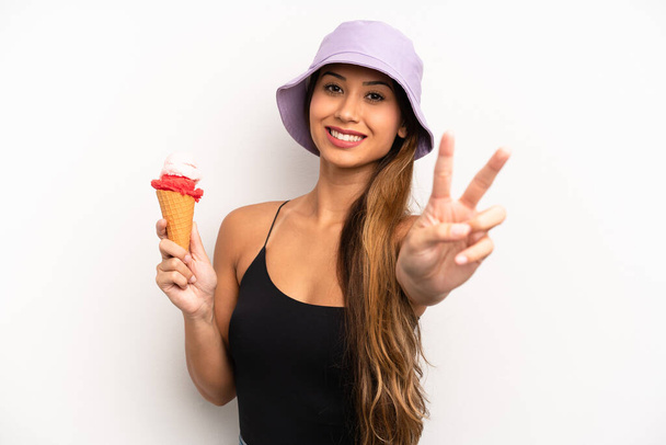 jovem mulher asiática sorrindo e olhando feliz, gesticulando vitória ou paz. conceito de verão e sorvete - Foto, Imagem
