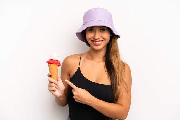 asian young woman smiling cheerfully, feeling happy and pointing to the side. summer and ice cream concept - Photo, image