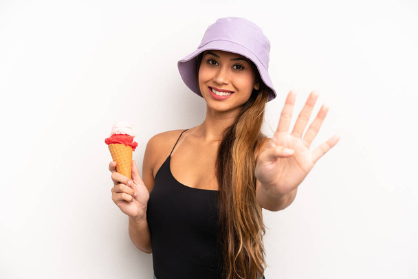 asian young woman smiling and looking friendly, showing number four. summer and ice cream concept - Fotoğraf, Görsel