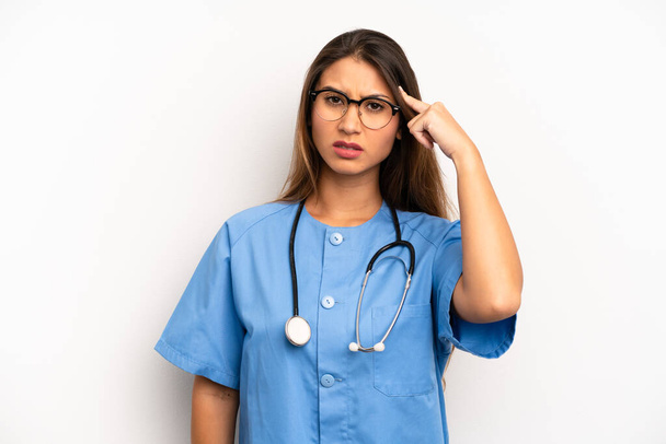 asian young woman feeling confused and puzzled, showing you are insane. nurse or doctor concept - Foto, Imagen