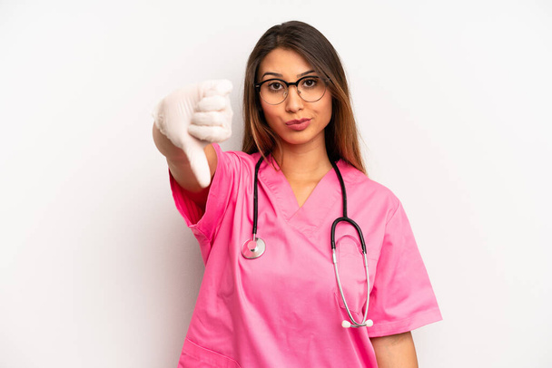 asian young woman feeling cross,showing thumbs down. veterinarian student concept - Foto, Imagen