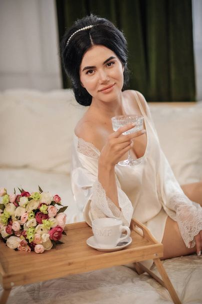 beautiful bride with a bouquet of white roses in a glass vase - Foto, immagini