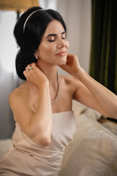 kaunis nuori nainen valkoisessa mekossa poseeraa huoneessa - Valokuva, kuva