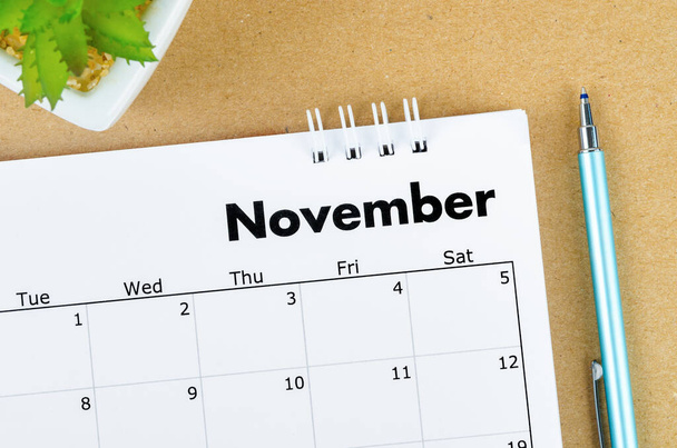 November 2022 desk calendar on brown background. - Foto, imagen