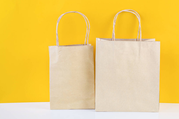 Vintage brown paper bags on yellow background. - Fotoğraf, Görsel