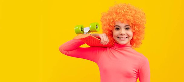 Happy girl child with orange hair in pink poloneck smile holding penny board, pennyboard. Funny teenager child on party, poster banner header with copy space - Φωτογραφία, εικόνα