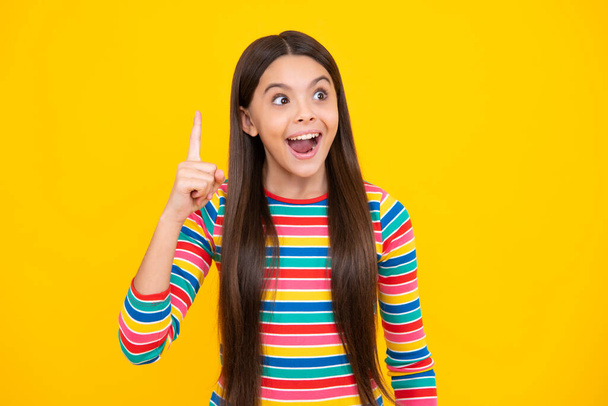 Excited teenager girl. Confident and successful young teenager child over isolated yellow background showing and pointing up with finger number one. Kid have an good idea - Φωτογραφία, εικόνα
