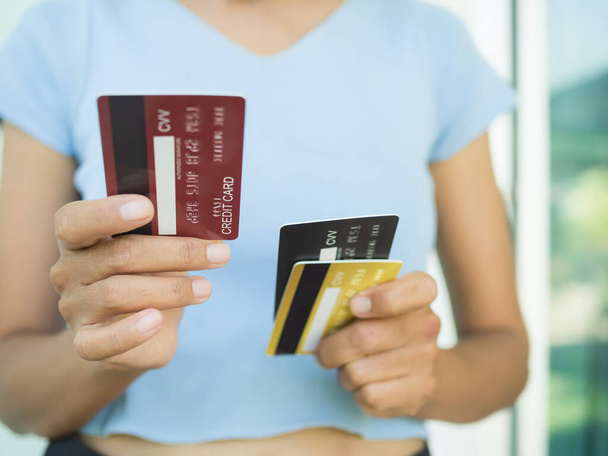 Close up woman holding credit card. for payment shopping, loan or give. plan investment income for 2023 new year. money cash in bank. technology comunication debit card for business or finance concept - 写真・画像