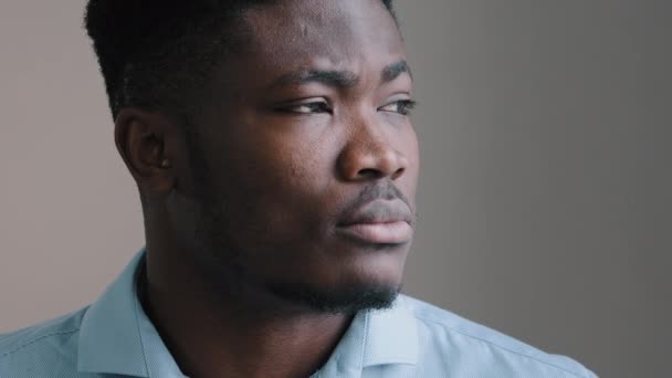 Close-up portrait male face african young man brunet model guy contemplate thoughtful look away turn head at camera expressing serious emotion american adult businessman boss feel confidence calmness - Filmati, video