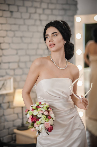 beautiful bride in a white dress with a bouquet of flowers - Foto, Imagen