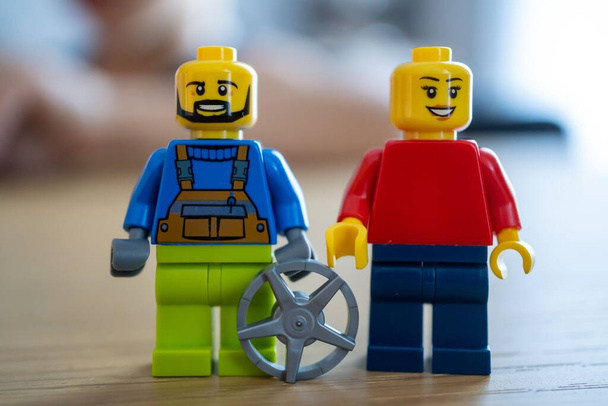 A Lego woman and man figurines with a wheel - Foto, afbeelding
