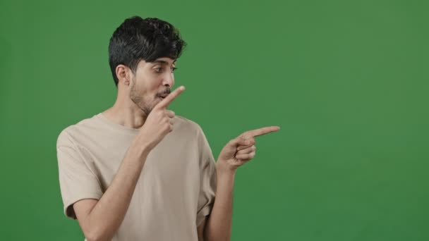 Optimistický humorný portrét arabský muž pózující v zelených studiových bodech ukazováčky stranou předstírání střelby pistole dělá výběr palec nahoru schválit dobrý nápad inzeruje propagační produkt image mockup - Záběry, video
