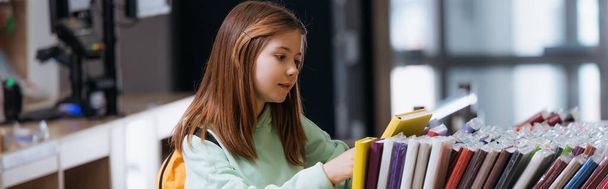 schoolgirl choosing from different notebooks in stationery shop, banner - Photo, Image
