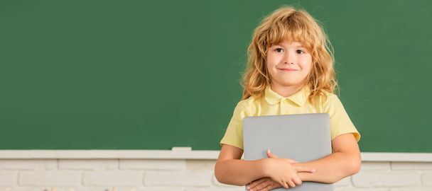 Školní žák na tabuli, banner copy space. e-learning. dítě studuje s počítačem. Veselý dospívající chlapec ve třídě. zpět do školy - Fotografie, Obrázek