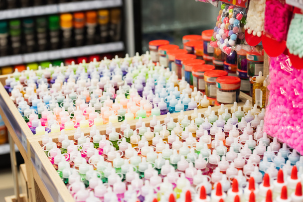 glue and paints near push pins in stationery store - Foto, Imagen