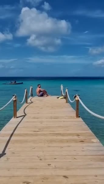 Острів Куракао Кариби, пляж Кокомо Вид навколо карибського острова Кюракао в яскравий день, людина в плаванні недалеко від пляжу, чоловіки на пляжі. - Кадри, відео