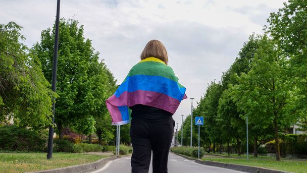 Biseksualny, lesbijski, kobiecy, transgenderowy spacer z tęczą Flaga LGBTQIA POKÓJ na drodze, spacer i świętowanie Dnia Biseksualizmu lub Narodowego Dnia Wyjścia, Duma miesiąc - Zdjęcie, obraz