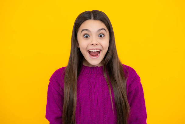 Excited kids face. Amazed expression, cheerful and glad. Excited teenager girl opening mouth in excitement, believe big sale or promo on yellow studio background, copy space - Photo, image