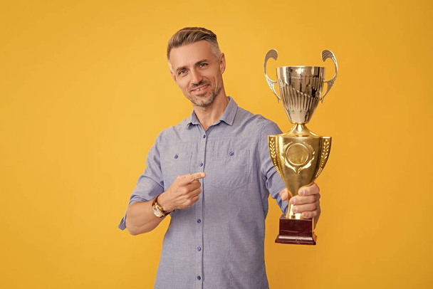 siling muž ukazující prstem na zlatý pohár, úspěch. - Fotografie, Obrázek