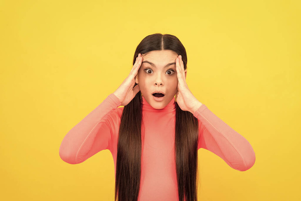 shocked teen girl with long hair on yellow background, emotions. - Zdjęcie, obraz