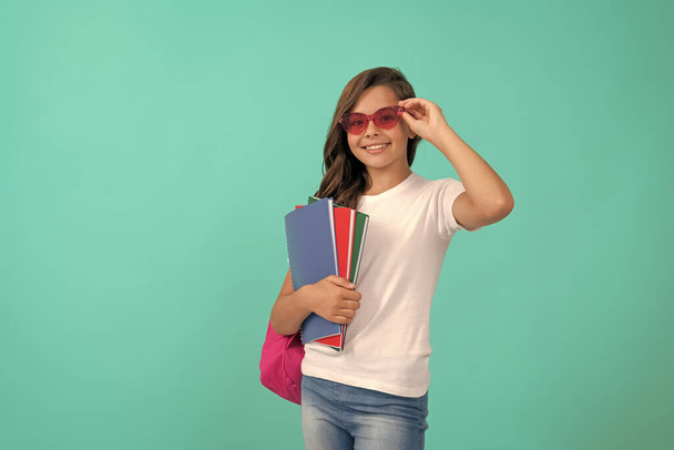 学校に戻って。知識の日だ。教育だ。眼鏡の子はコピーを持ってる。9月1日子供時代。学校の袋を持った生徒が宿題をします。幸せな女子高生はリュックとノートパッドを持って. - 写真・画像