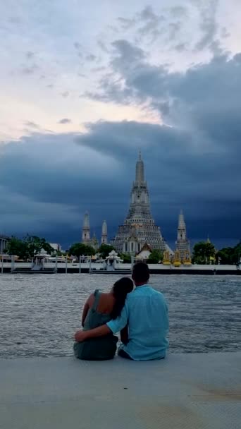 Ват-Арун Храм світанку Ландмарк в Бангкоку, Таїланд протягом полудня в Бангкоку, пара чоловіків і жінка на набережній в Бангкоку під час дощового сезону мусонів - Кадри, відео