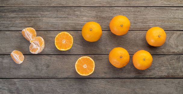 Mandarinas con fruta cortada sobre mesa de madera. - Foto, imagen