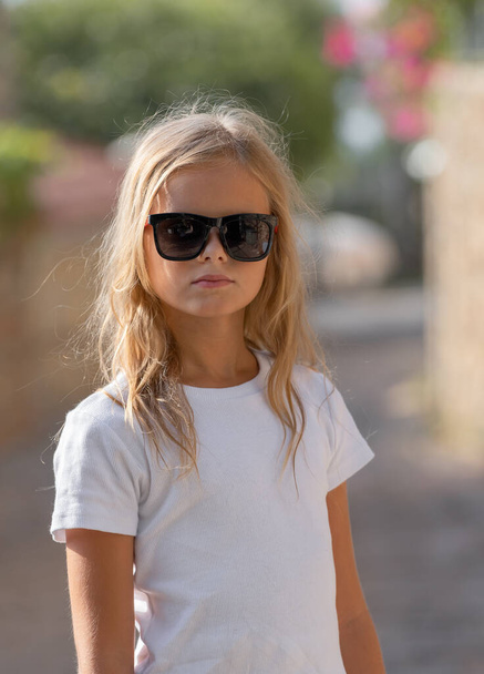 Outdoor portrait of a cute young girl in sunglasses. - Fotoğraf, Görsel
