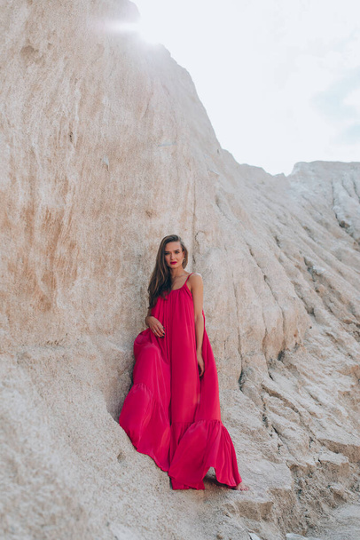 beautiful young woman in red dress posing outdoors - Foto, imagen