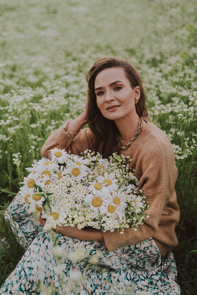 young woman with basket with flowers in the field  - Photo, Image