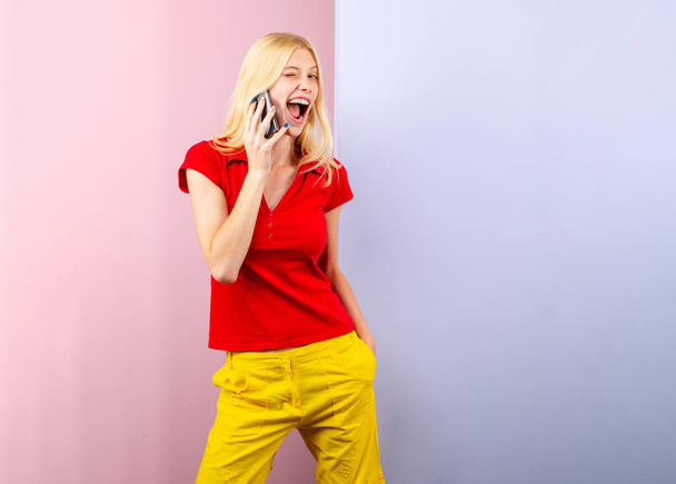 Cute surprised young woman chatting by mobile phone isolated background. Phone talking - Фото, зображення