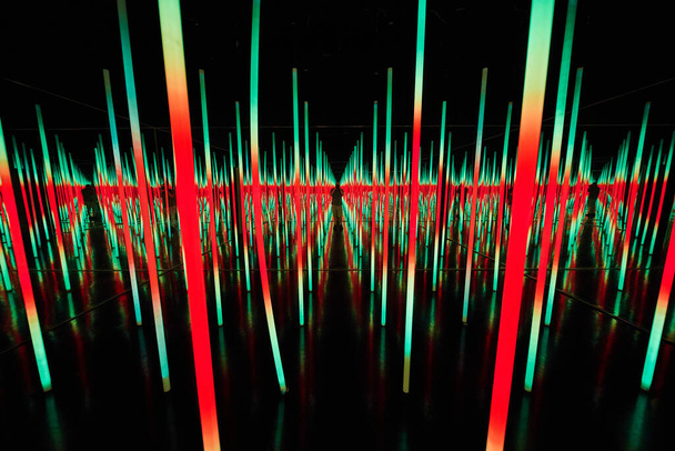 Immagine di pali luminosi a LED verdi e rossi in una stanza a specchio a sfioro - Foto, immagini