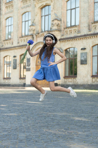 glad teen girl in headphones. girl jump outdoor. carefree girl jumping feel happiness. - Foto, immagini