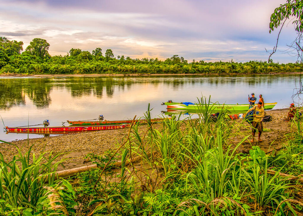 Jungle, Indonesia - January 13, 2015: Colourful boats  on the banks of the river during the sunset. - Zdjęcie, obraz