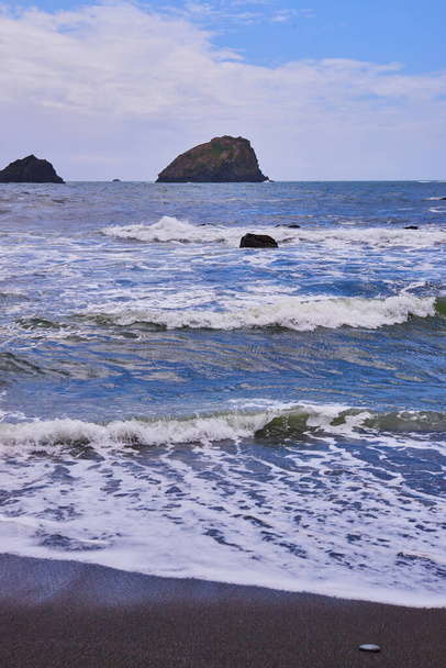 Εικόνα της δυτικής ακτής μαύρη αμμουδιά με μικρά κύματα να συντρίβονται - Φωτογραφία, εικόνα