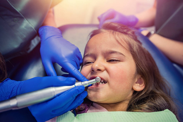 молода стоматологка чистить зуби для маленької дівчинки. Концепція чищення зубів у дитини
 - Фото, зображення