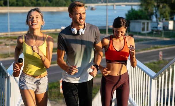 Fitness sport people running lifestyle concept. Group of young people jogging together to stay healthy outdoors. - Foto, Bild