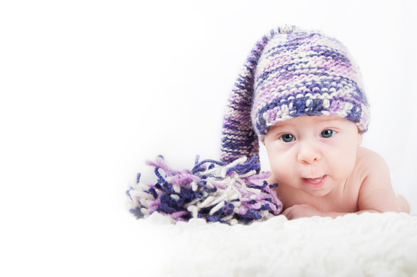 Novorozeně v barevné funny dlouhých klobouku při pohledu na fotoaparát - Fotografie, Obrázek