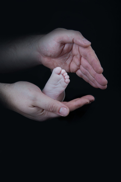 bebek bacakları. bacaklar siyah bir arka plan üzerinde yeni doğan - Fotoğraf, Görsel
