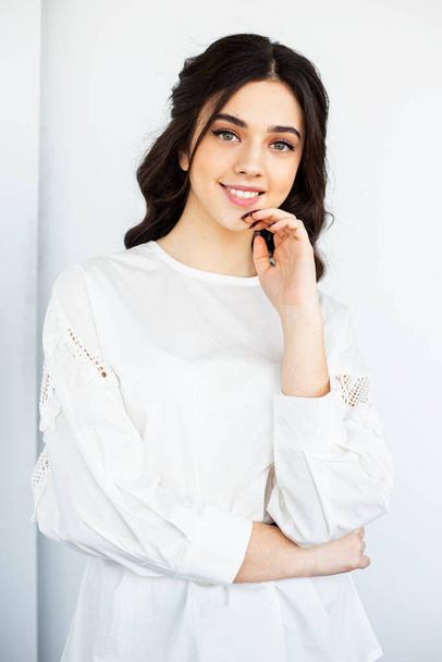 Krása přední portrét krásné usmívající se mladé ženy nosit bílou košili, pózování ve studiu, izolované bílé pozadí. - Fotografie, Obrázek