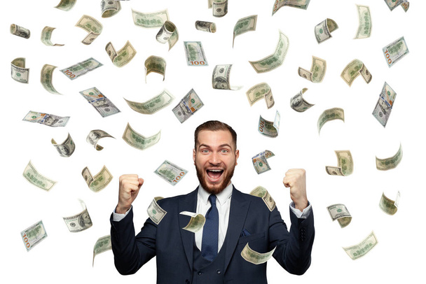 Умный счастливый успешный молодой бизнесмен веселится в падении 100 долларов наличными деньгами изолированы на белом - Фото, изображение