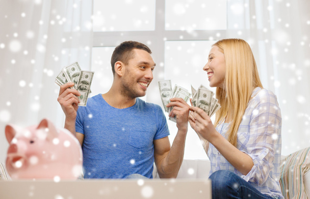 happy couple with money and piggybank at home - 写真・画像